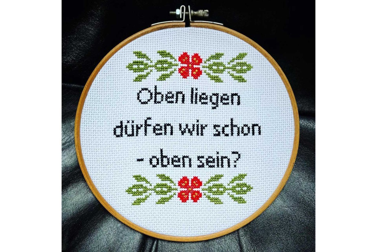 Cross-stitch object with text "Can we lie on top - be on top?"