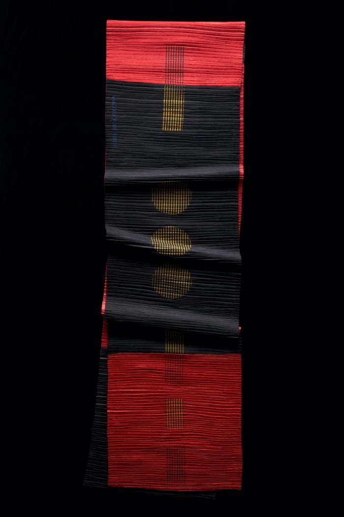 Kunstfaser, plissiert, beidseitig bedruckt in Rottönen