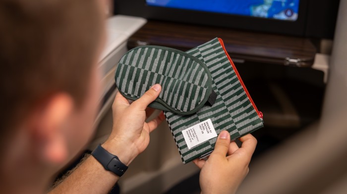 Person hält Amenity Kit mit Schlafmaske