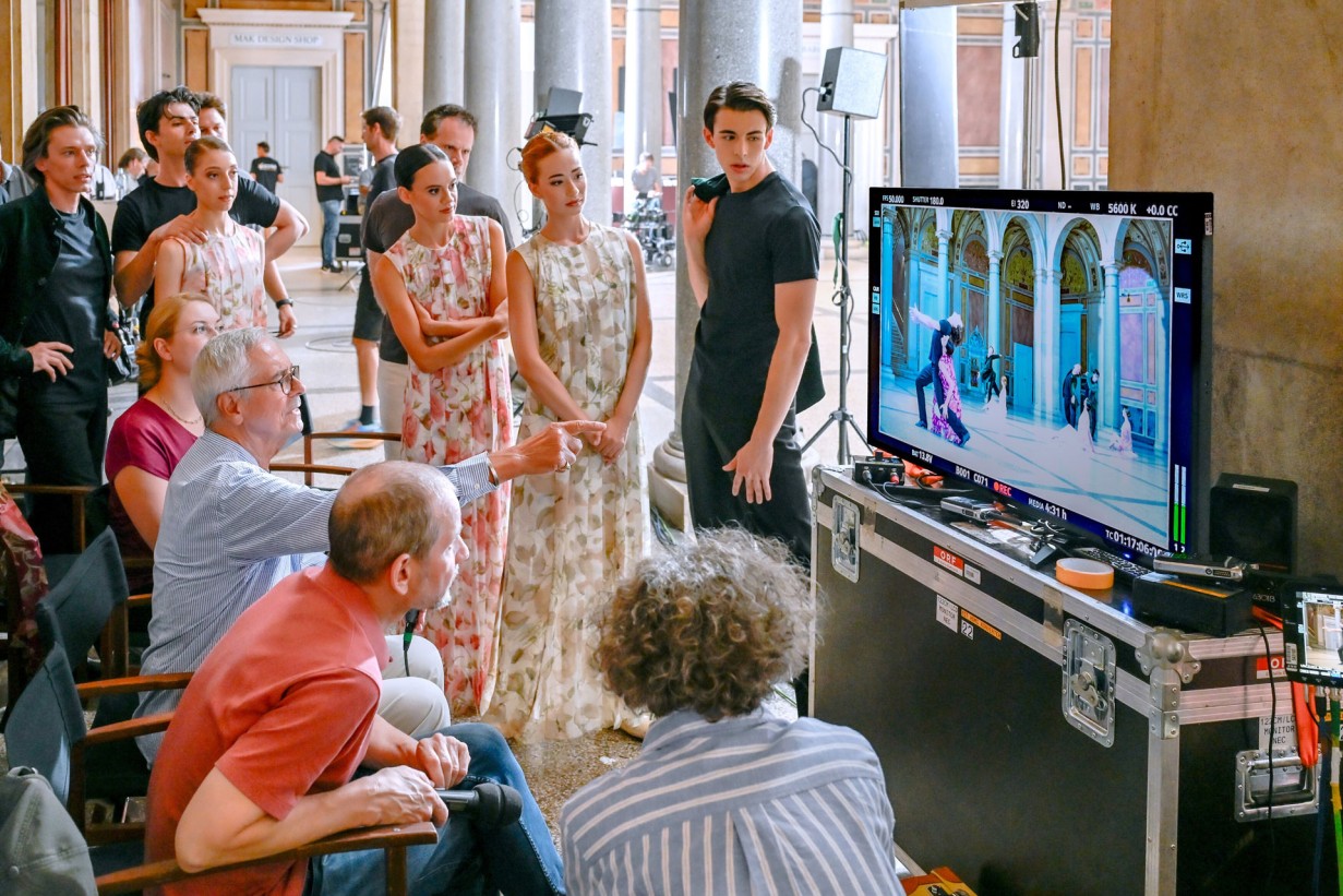 Tänzer*innen, Regisseure und Choreograph stehen um Screen und betrachten Aufnahmen