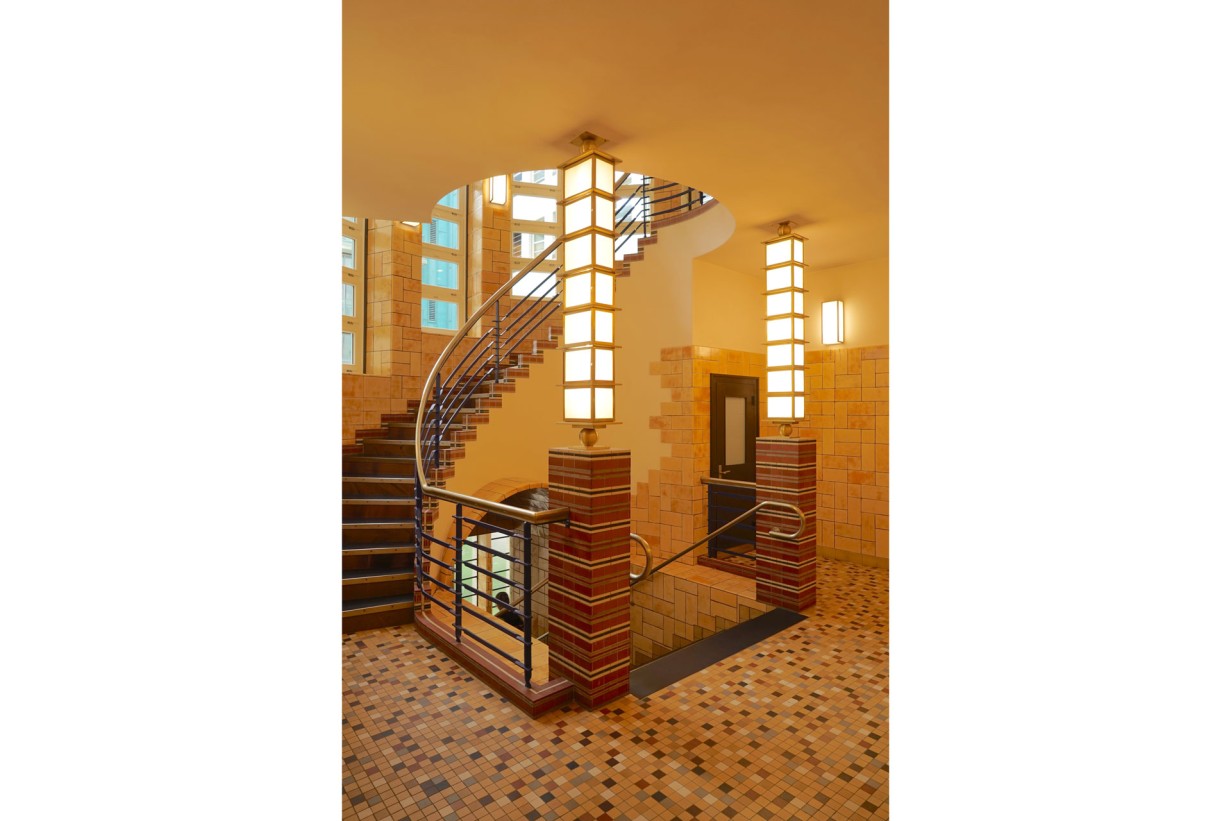 A staircase with a railing leading to an upper area surrounded by a bright environment.