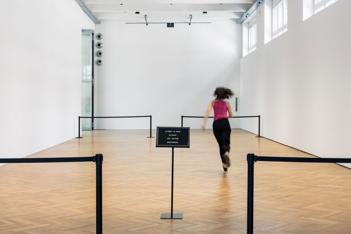 Eine Person bewegt sich durch einen Ausstellungsraum.