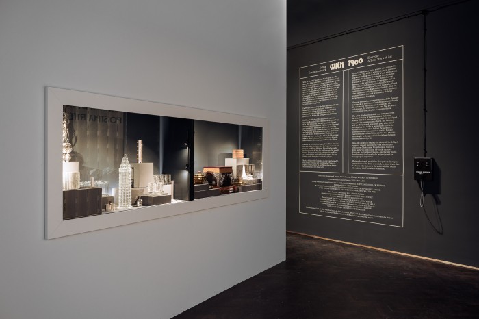 Wandtext zur Ausstellung und Vitrine mit Objekten