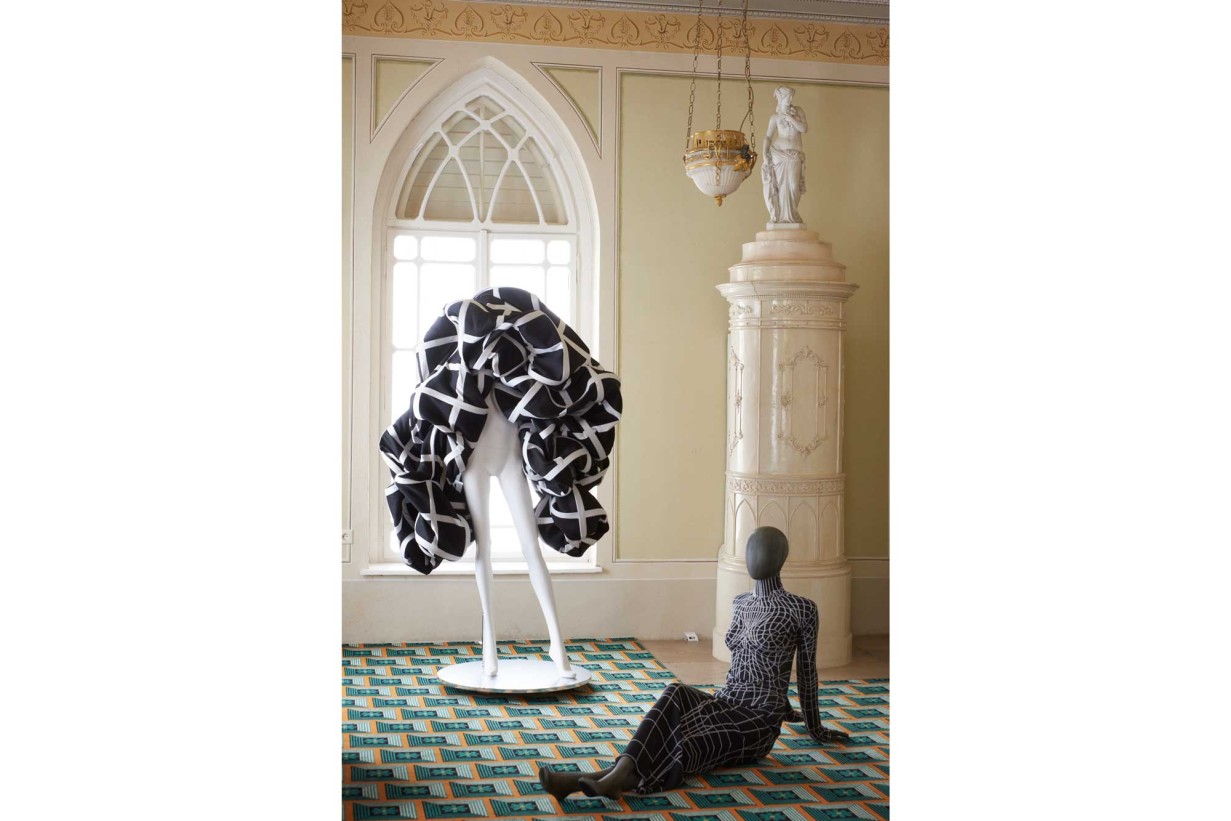 A room in Biedermeier style with mannequins, futuristic fashion designs wear. 