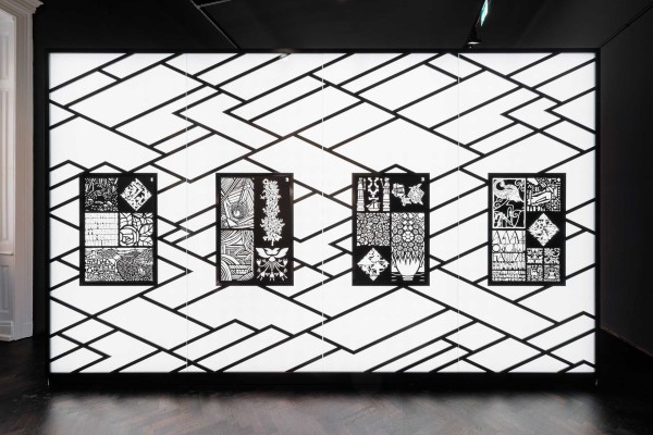 Wall illuminated from behind with geometric paper cutouts