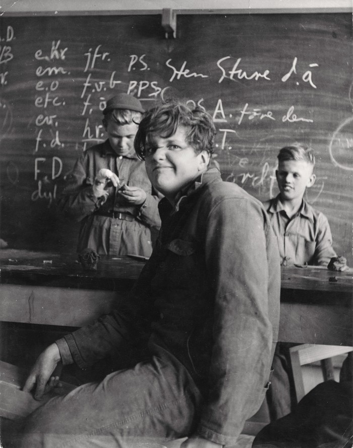 Junge in einem Klassenzimmer schaut in die Kamera