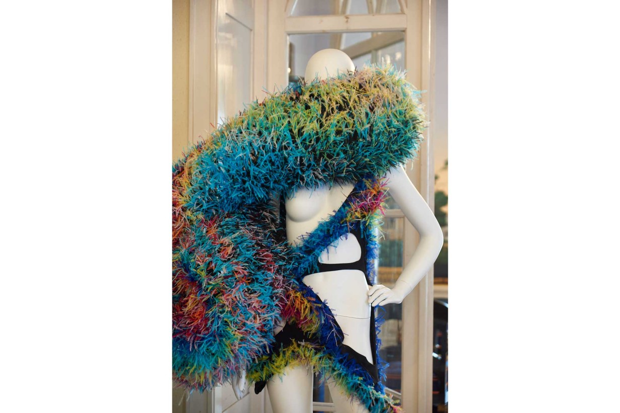 A mannequin around whose neck and body is wrapped a colorful object.
