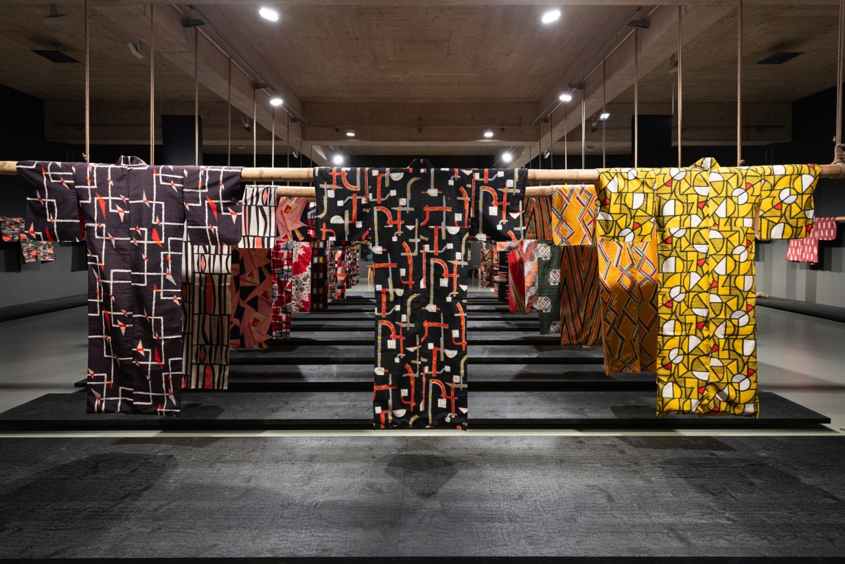 Ein Ausstellungsraum, von der Decke aus hängen bunte Kimonos