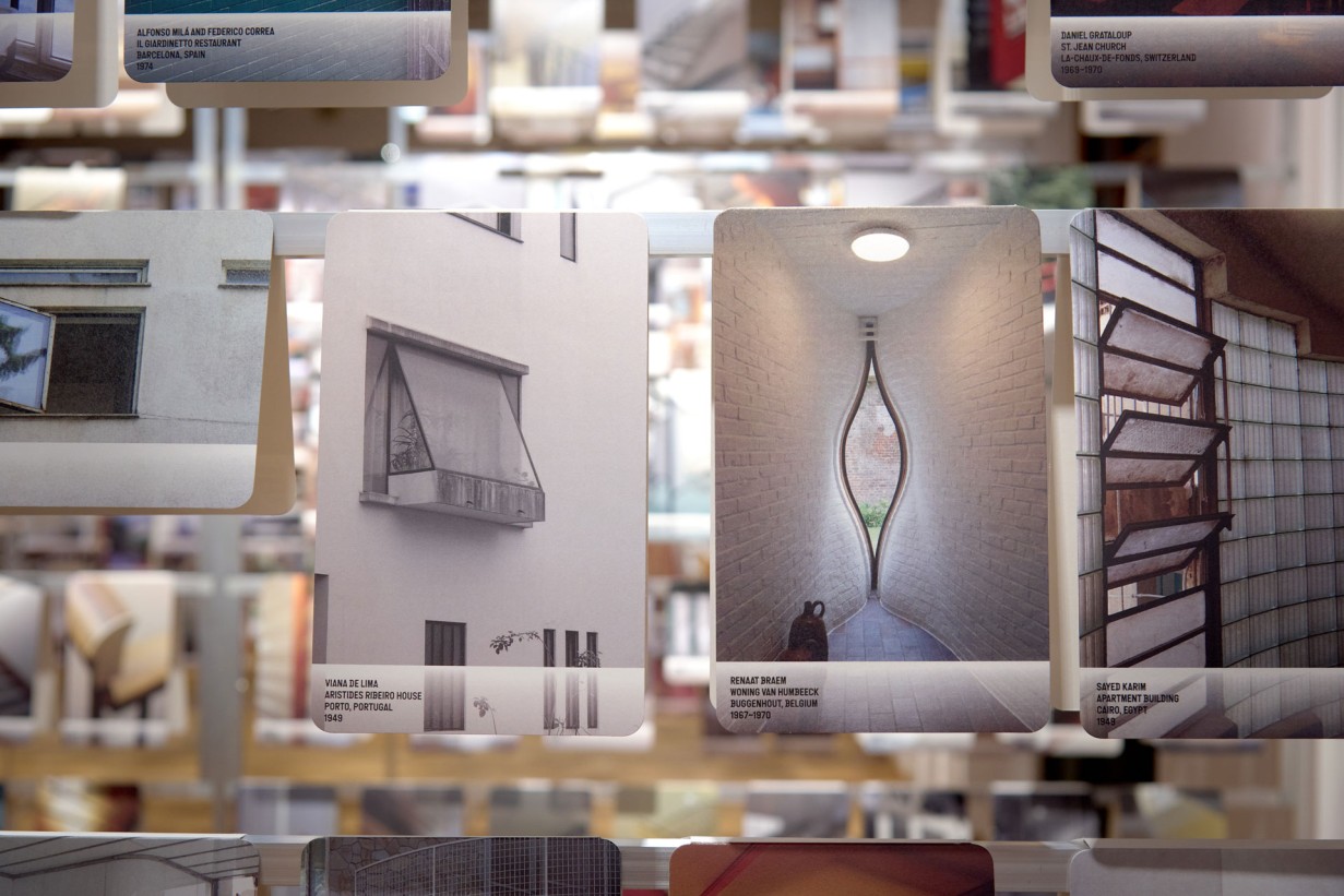 Many photos with detailed shots of architecture hang on scaffolding in an exhibition room.