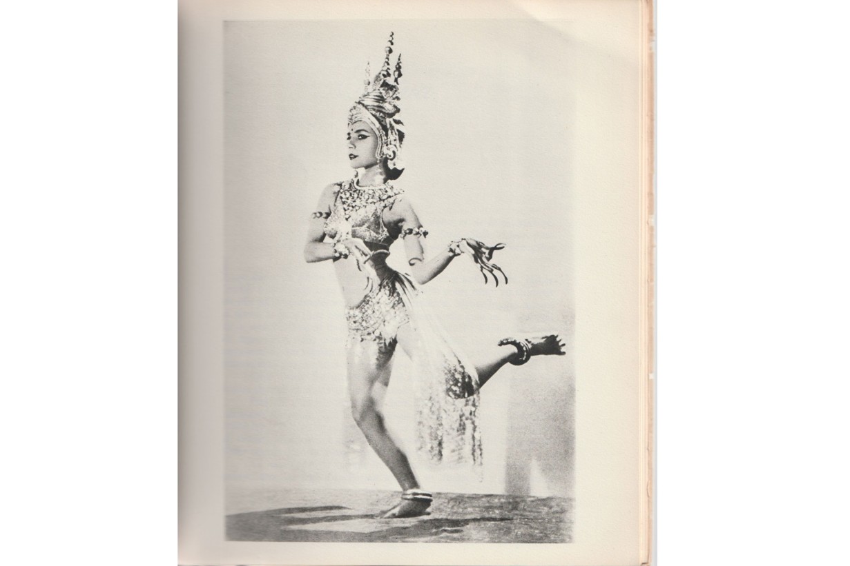 A dancer is wearing a V-neck top and short shorts made of shiny metallic fabric