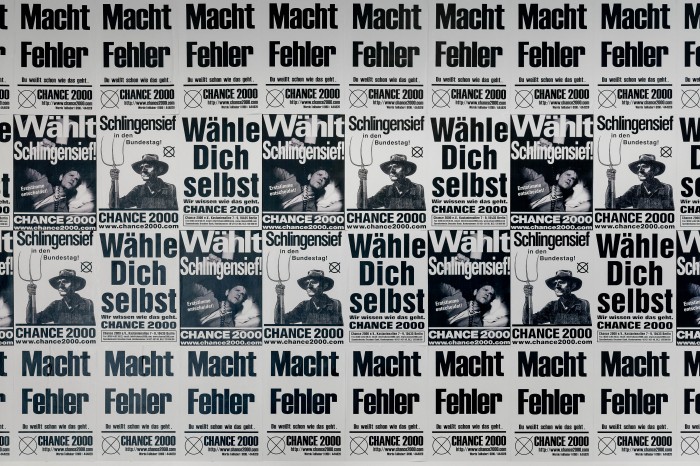 Plakatwand mit Slogans "Macht Fehler", "Wähle dich selbst", Wählt Schlingensief"