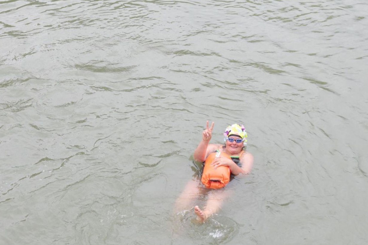 Person with bathing cap swims in the Danube Canal