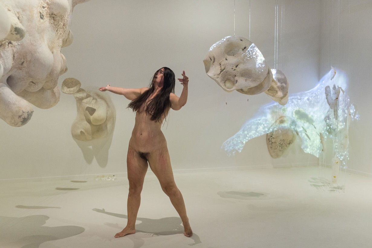 Performerin Doris Uhlich steht innerhalb der Installation einer 40.000-fachen Vergrößerung einer Amöbe