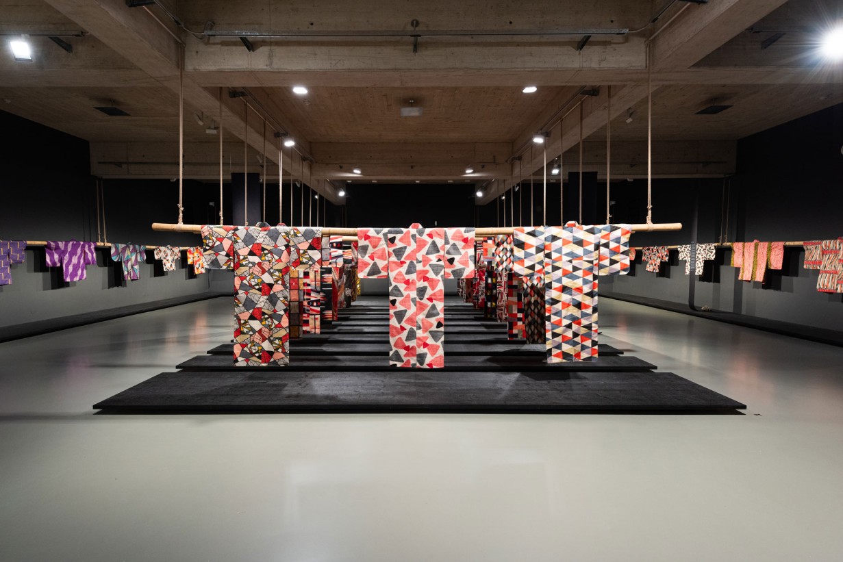 Ein Ausstellungsraum, von der Decke aus hängen bunte Kimonos