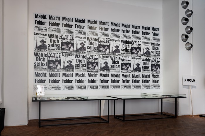 Plakatwand mit Slogans "Macht Fehler", "Wähle dich selbst", Wählt Schlingensief"