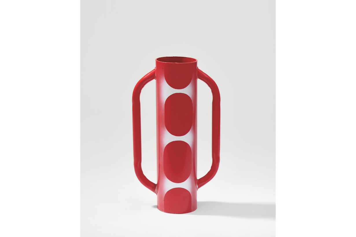 Eine Vase mit roten Punkten darauf.