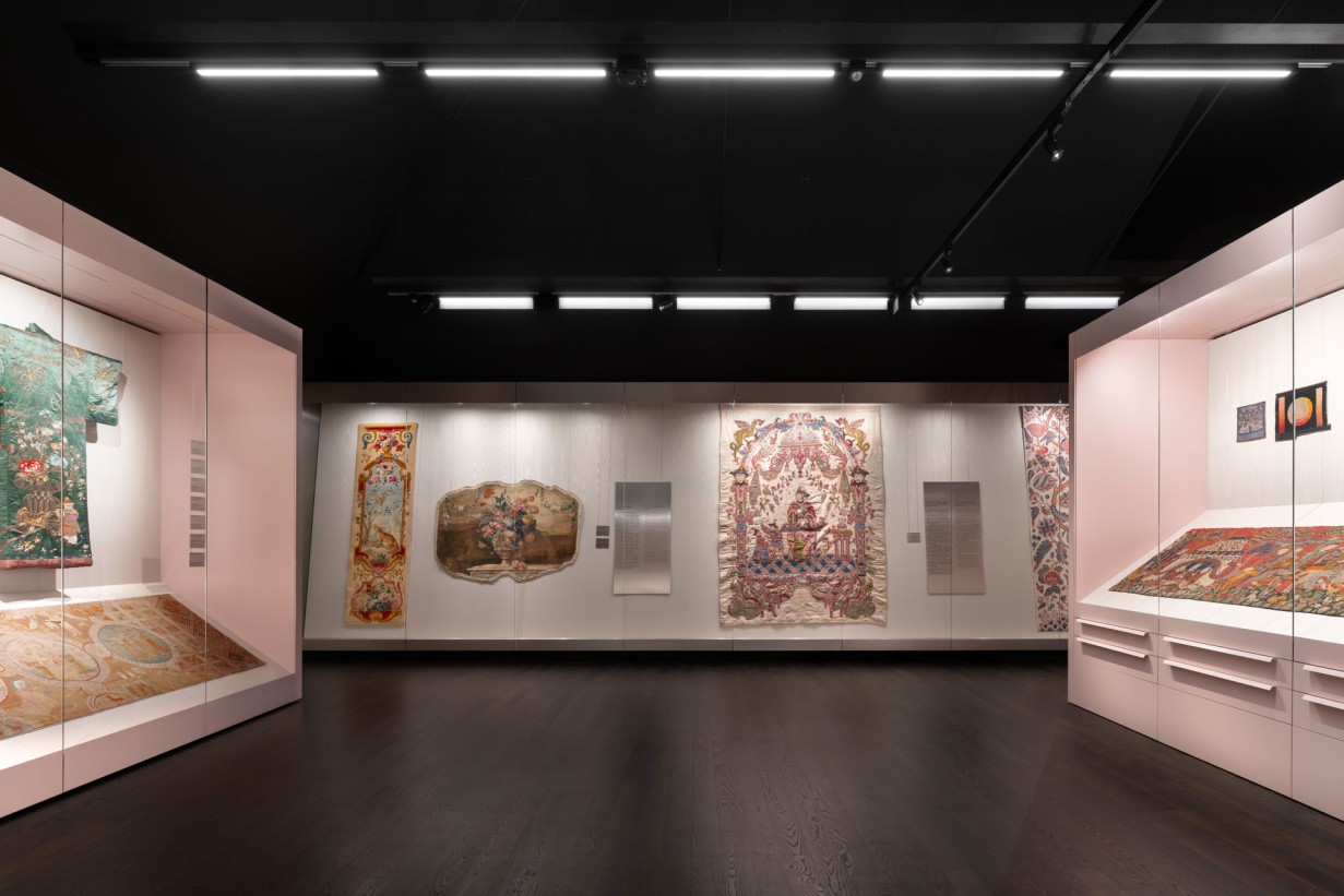 Display cases in the Textiles and Carpets Collection featuring various objects