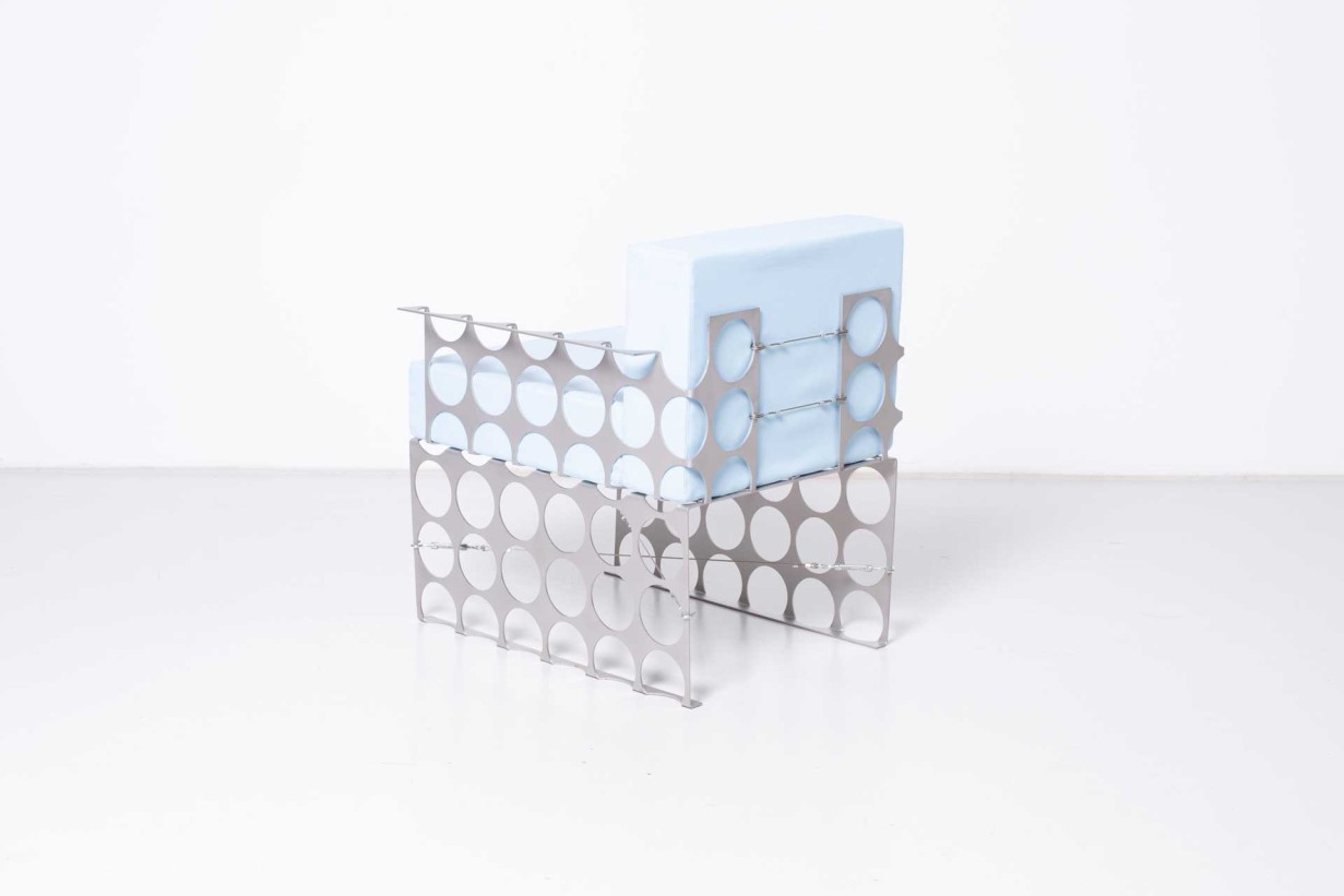 Ein Stuhl aus Metall mit blauem Kissen.