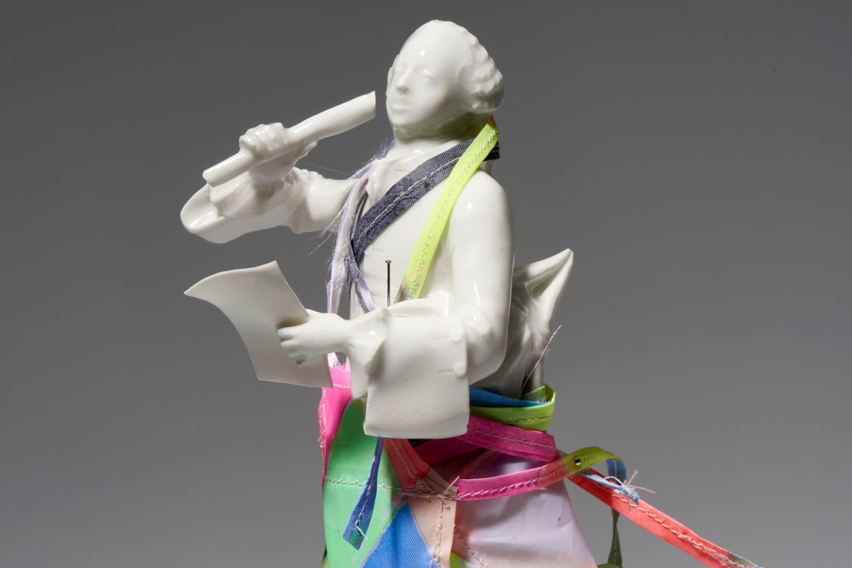 Eine kleine Porzellanfigut in weiß mit buntem Tüll