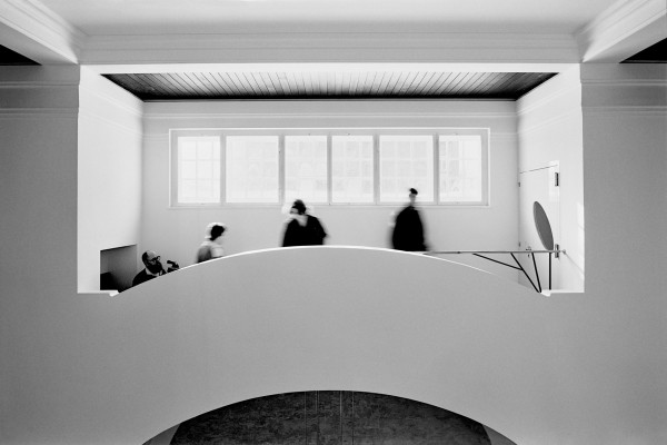 People are standing on a bridge indoors