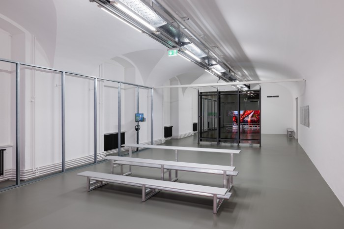 Ausstellungsraum mit Screens und Sitzbank