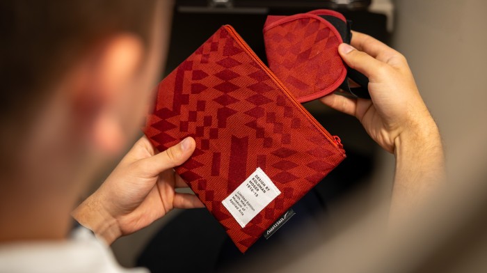 Person hält Amenity Kit mit Schlafmaske