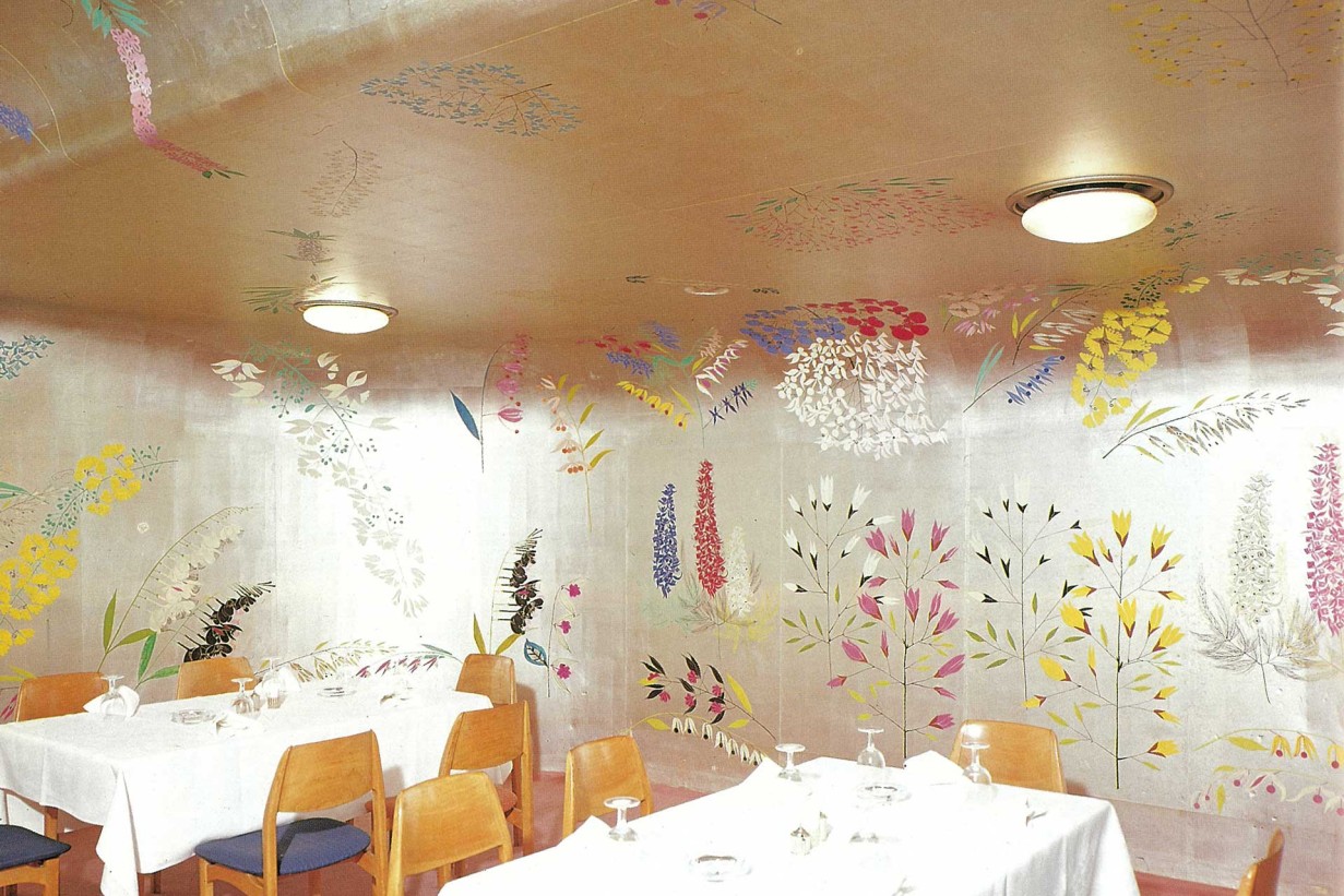 Restaurant with white tablecloths, walls with floral decorations