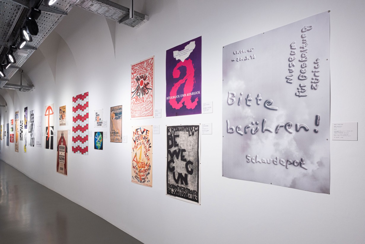 Ausstellungsraum mit Plakaten an der Wand