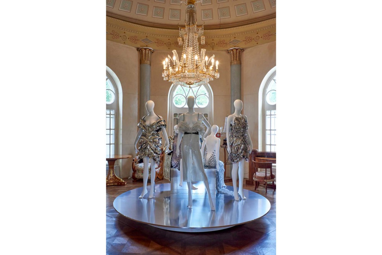 A room in Biedermeier style with mannequins, futuristic fashion designs wear. 