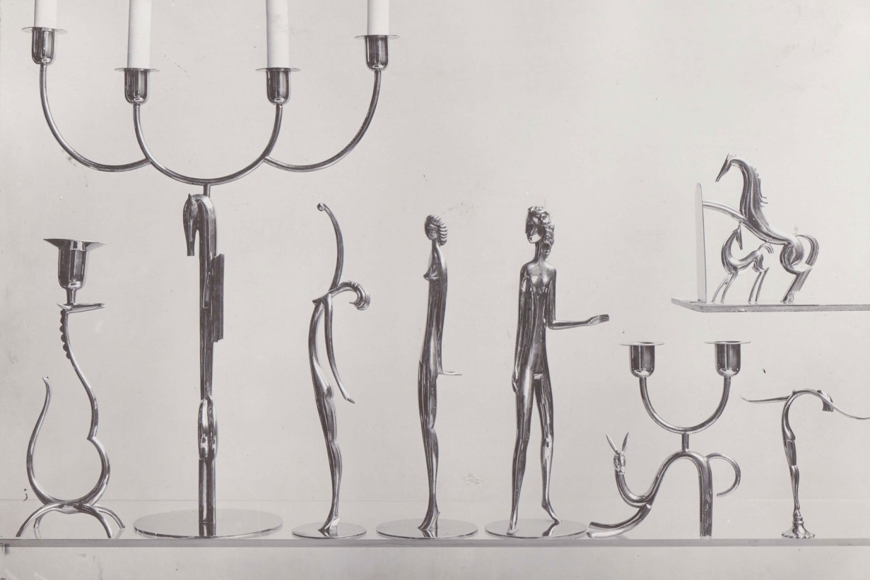 Ein zeitgenössisches schwarz-weiß Foto das weibliche Figuren und Tiere als Füße für Leuchter und Tischlampen zeigt. 