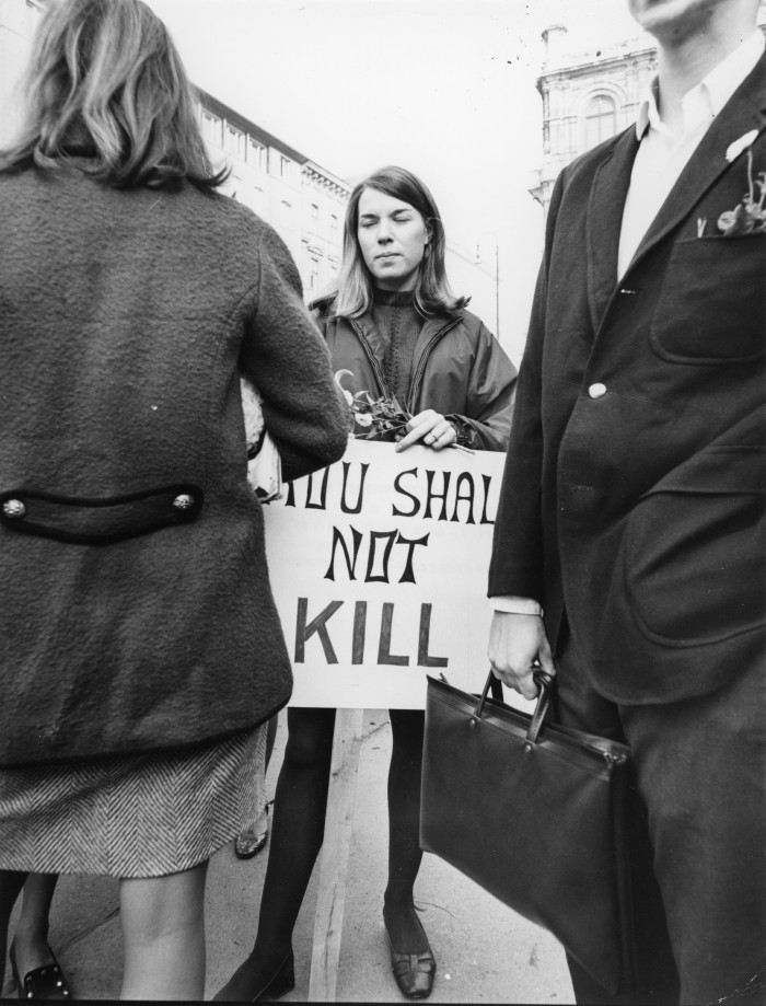 Junge Frau hält Protestschild: Thou shall not kill