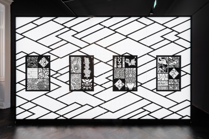 Wand von hintern beleuchtet mit geometrischen Scherenschnitten