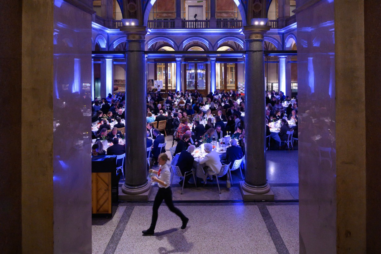 Gedeckte Tische mit Gästen in der MAK Säulenhalle