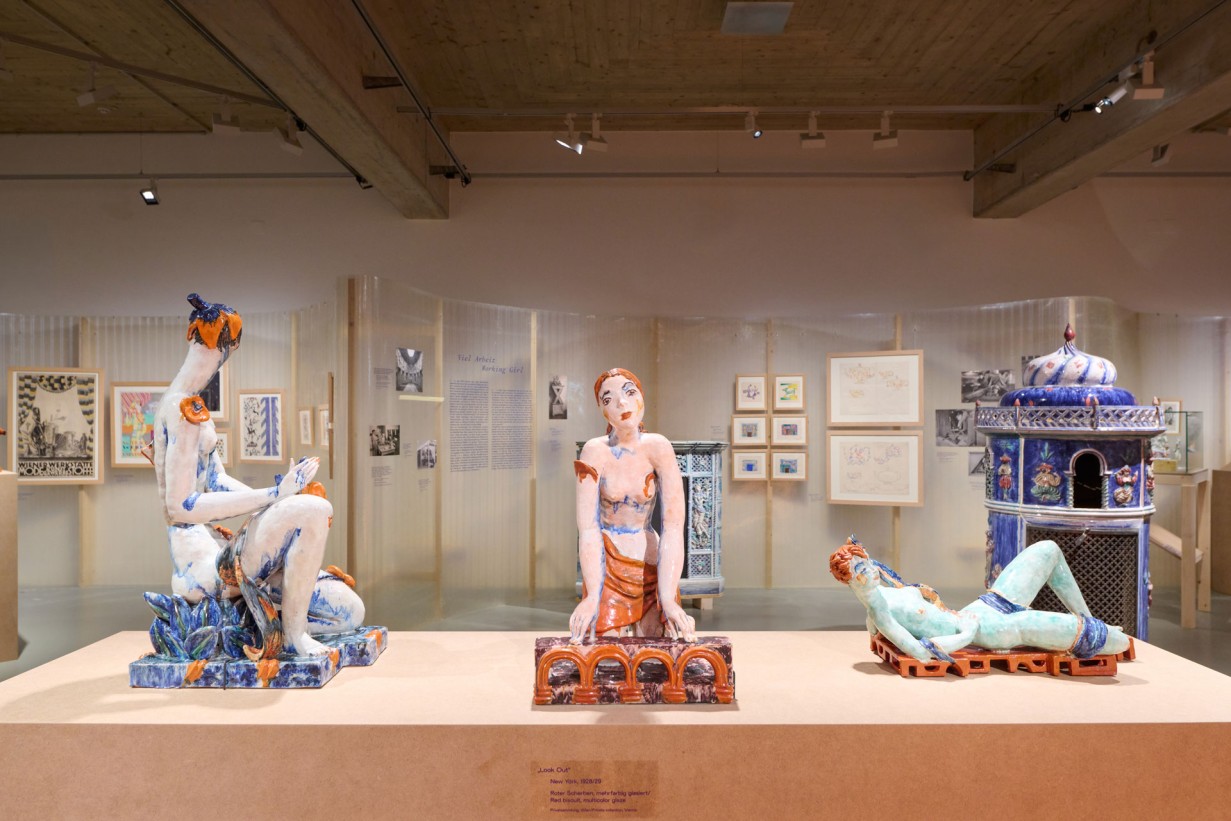 Exhibition view featuring a podium and sculptures by Vally Wieselthier