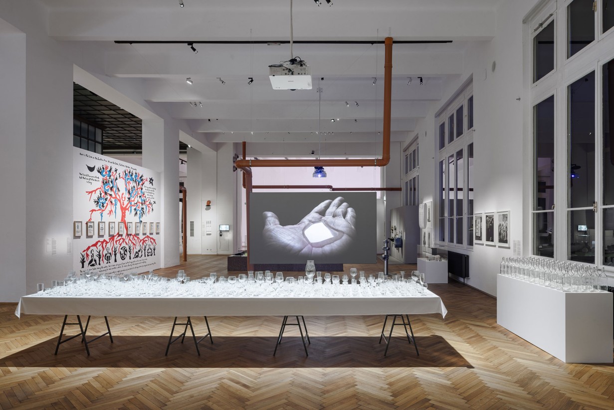 Ausstellungshalle, im Vordergrund ein Tisch mit zahlreichen Gläsern