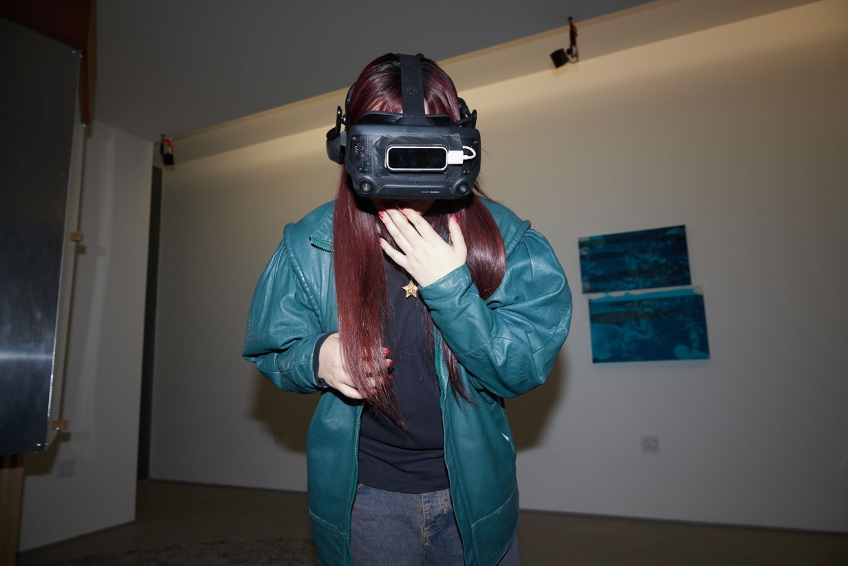 A woman with a college jacket wears VR glasses