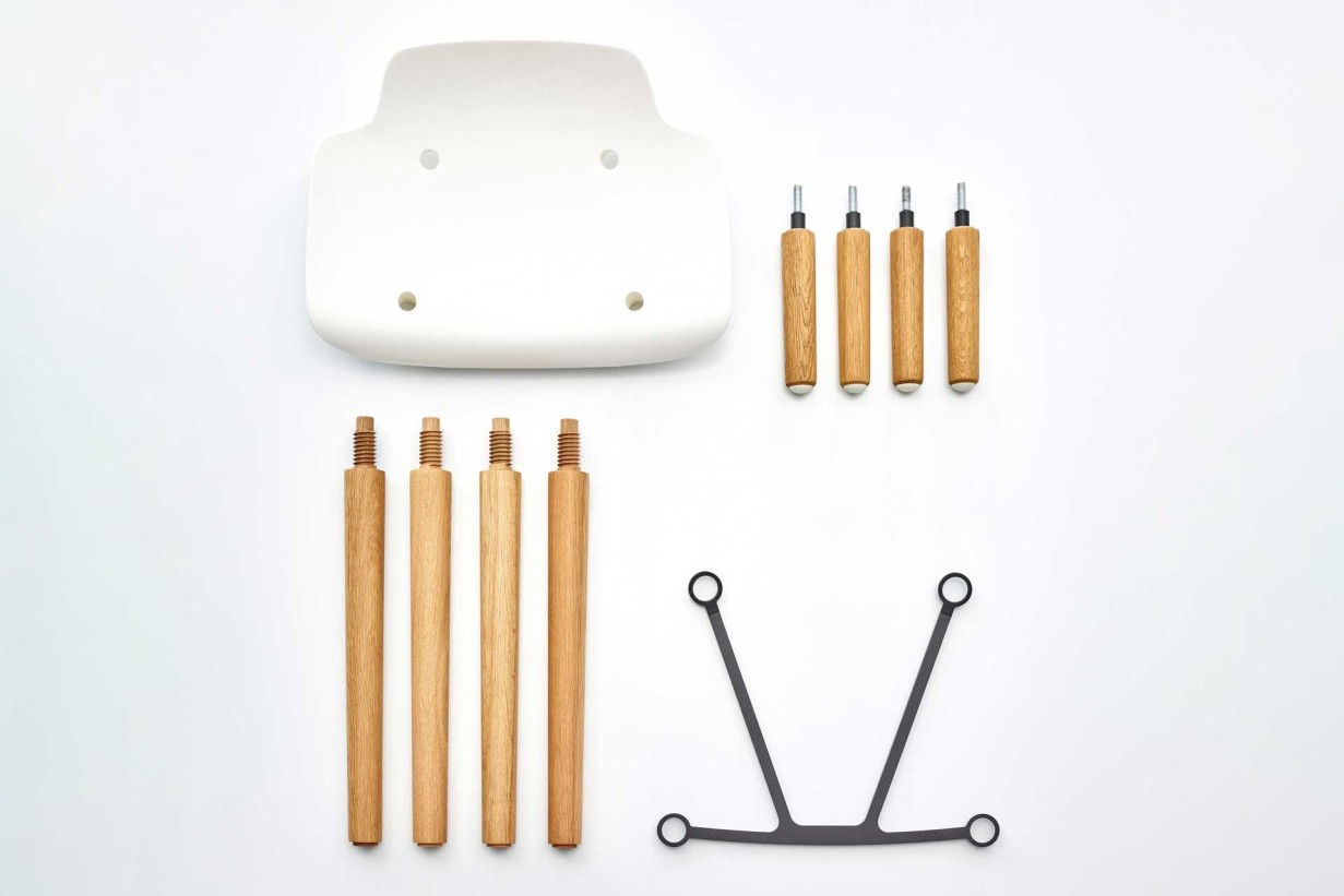 Abbildung eines dekonstruierten weißen Stuhls mit Holzelementen und einem Holzhocker.