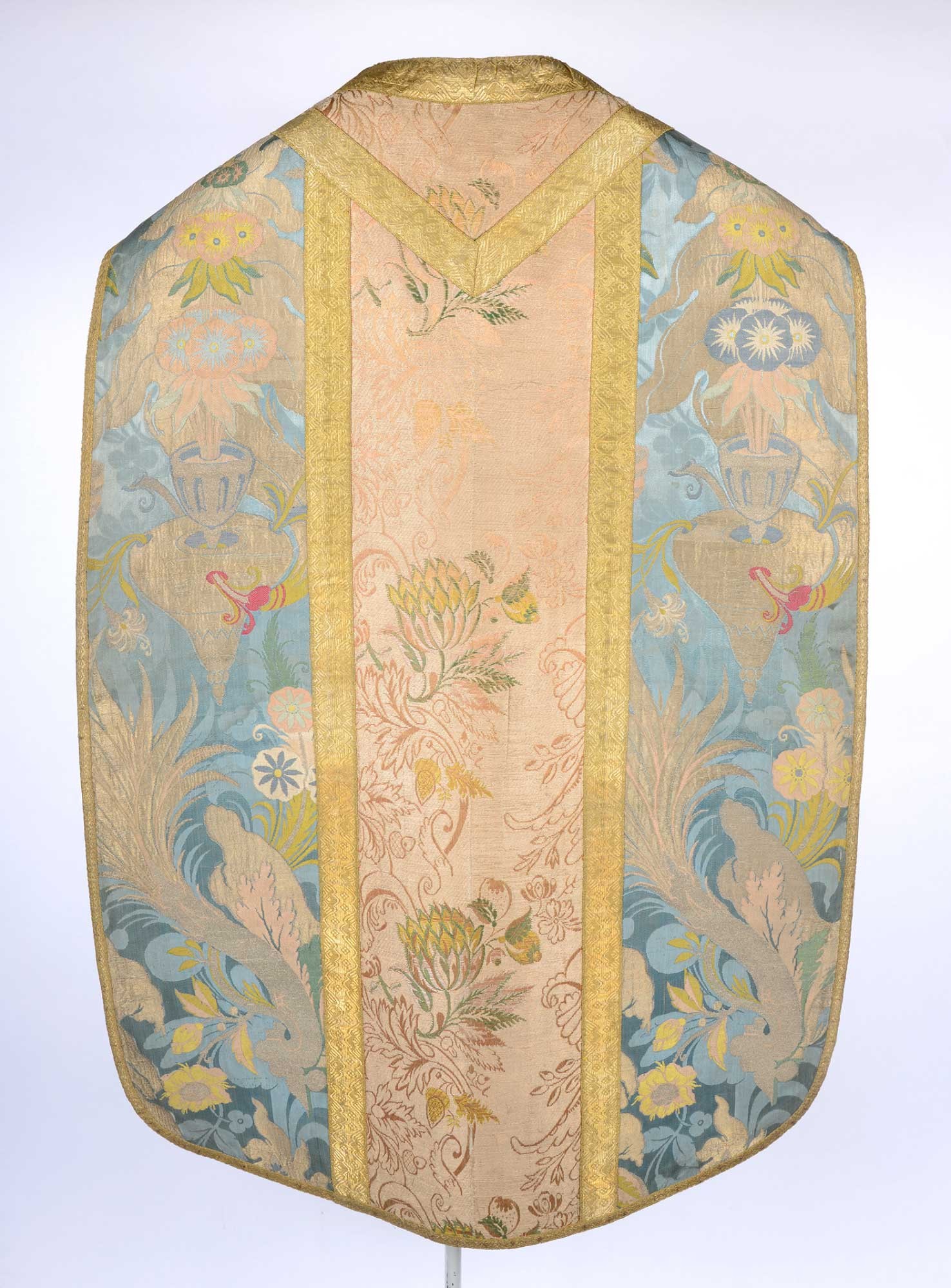 Chasuble made of two reused textiles: one blue with floral patterns of the “bizarre silk” type and one pale pink silk fabric with gold edging