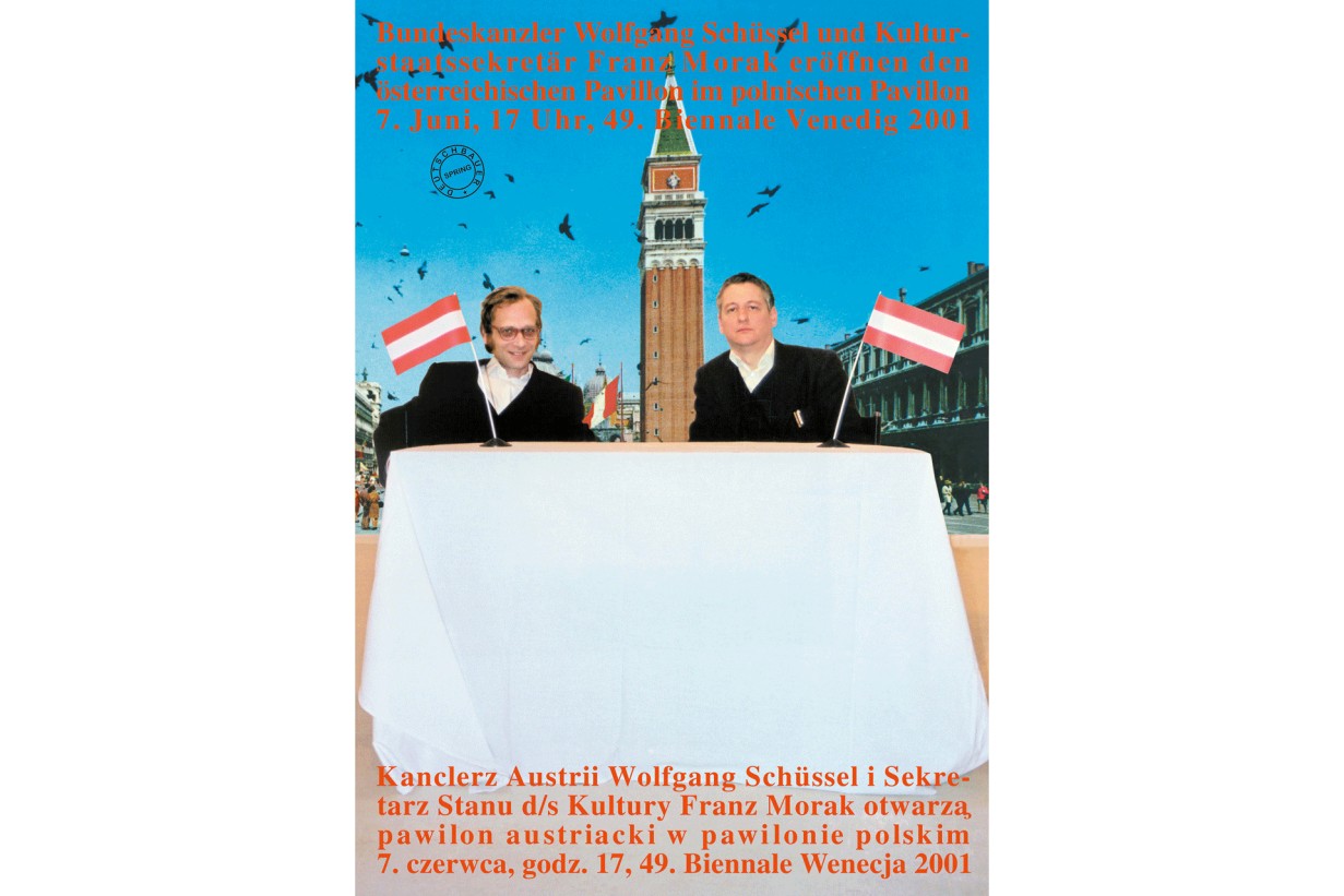 Zwei Männer sitzen an einem Tisch mit zwei österreichischen Flaggen, im Hintergrund ist der Markusplatz in Venedig zu sehen, 