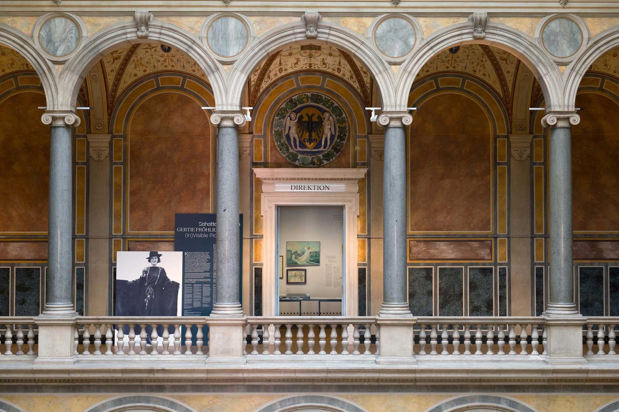 Ballustrade mit Säulen, dahinter sieht man in einen Ausstellungsraum