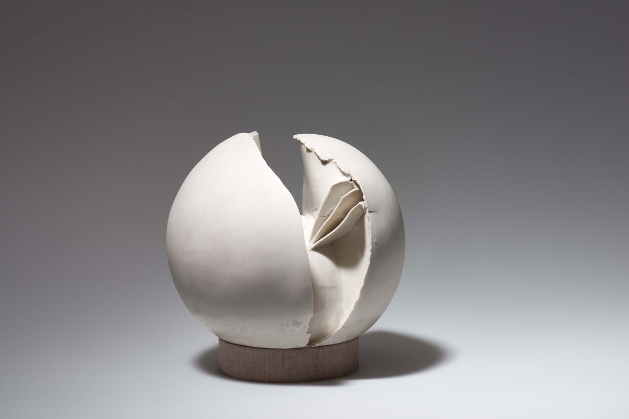 Kugelförmige Skulptur aus weißem Porzellan, in der Mitte durchgebrochen