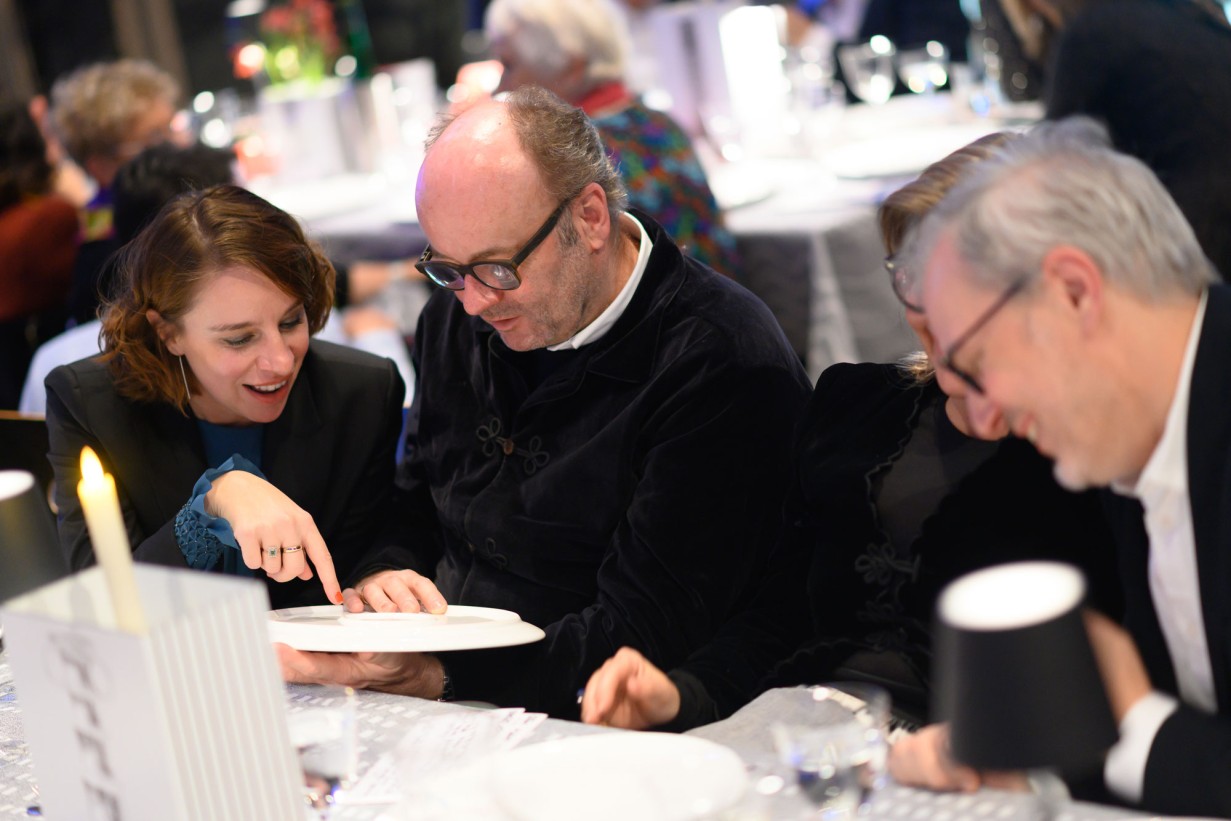 Gäste des MAK Künstler*innendinners betrachten die Sonderedition