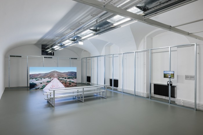 Ausstellungsraum mit Screens und Sitzbank