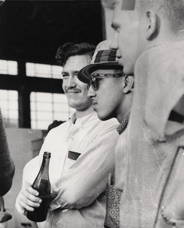 Profilansicht von drei jungen Männern, einer hält Flasche