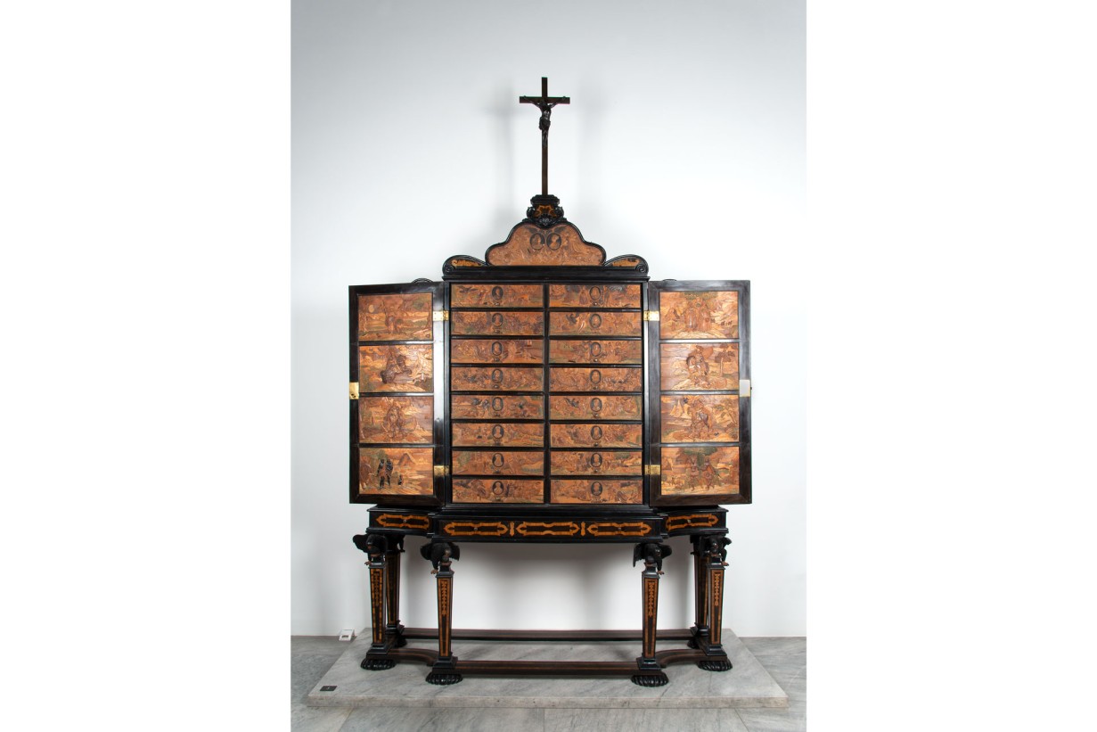 Ein Schrank mit Schubladen und einem Kreuz auf der Oberseite.