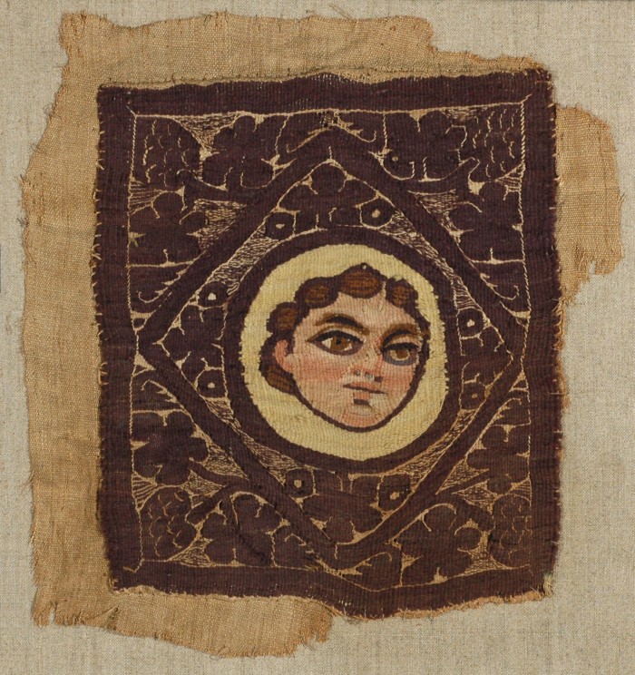 Quadratisches Zierstück mit Gesicht im Zentrum