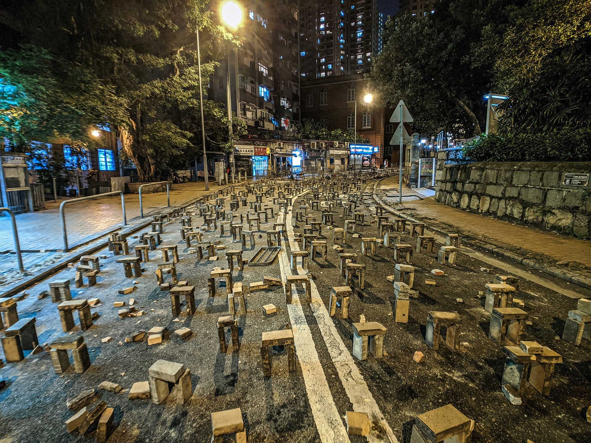 Barrikaden auf den Zufahrtsstraßen zur Hong Kong University. Ziegelsteine wurden teilweise mit Sekundenkleber auf dem Asphalt fixiert, sodass Fahrzeuge der Polizei nicht zum besetzten Campus vordringen konnten.