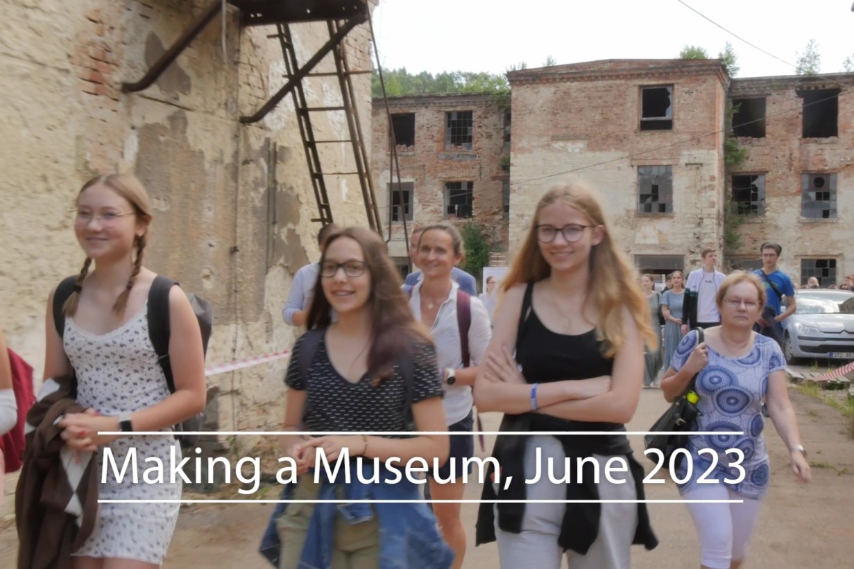People in a courtyard surrounded by dilapidated buildings