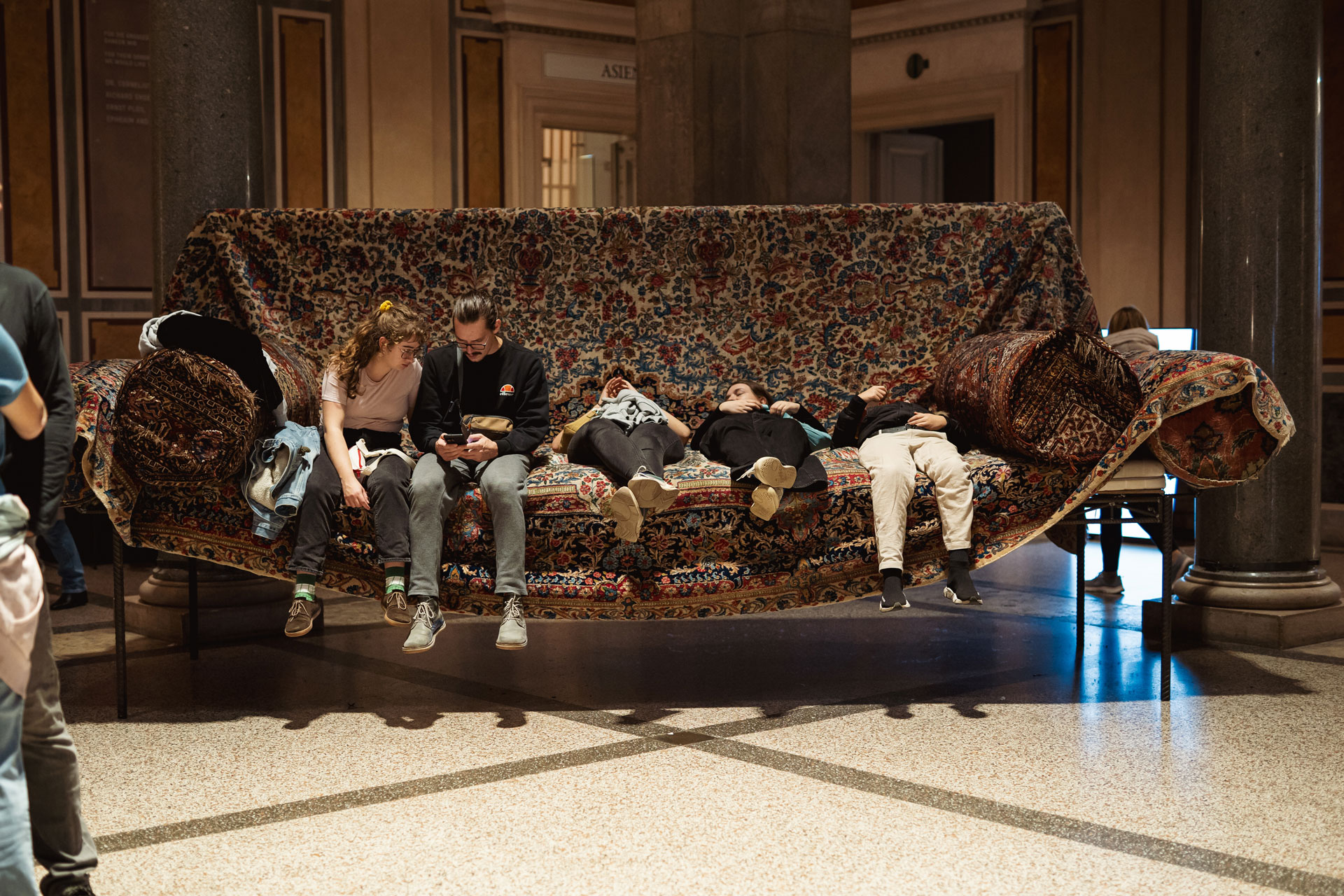 Besucher*innen auf einem überdimensionalen Sofa